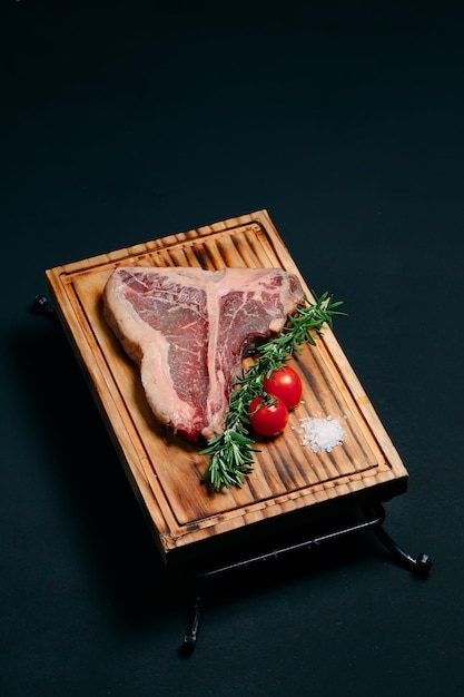 Raw meat steak t-bone on a black background.