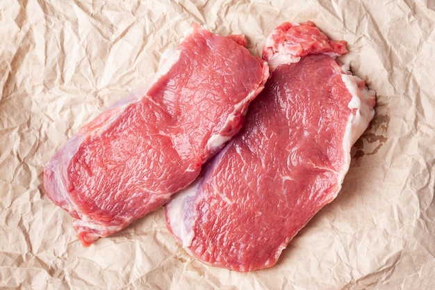 Raw meat Top view of two slices of fresh raw meat on paper Preparing meat for a barbecue