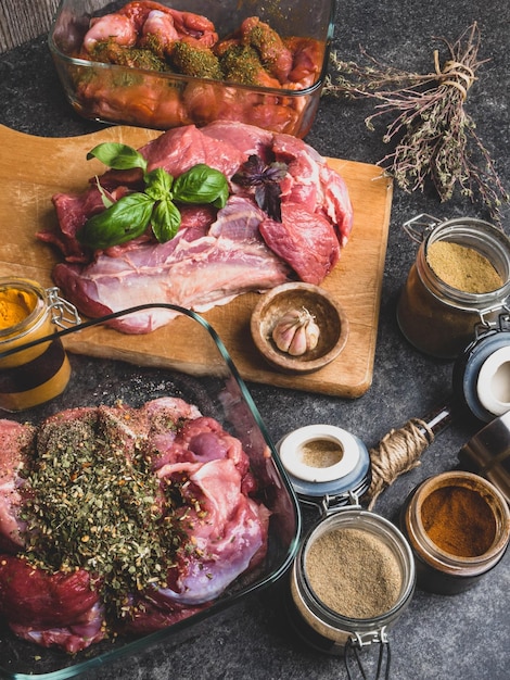 Raw meat with herbs spices sauces on concrete background Top view