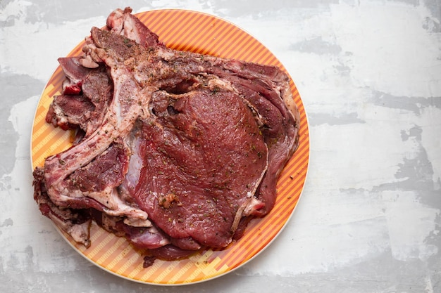 Raw meat with marinate on big dish on ceramic