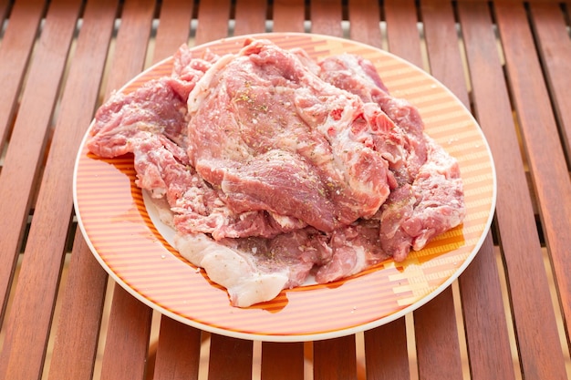 Raw meat with marinate and herbs on dish