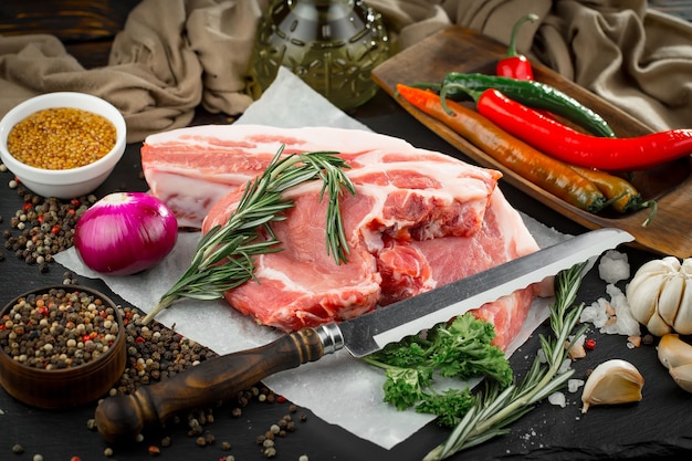 Raw meat with spices in a composition with kitchen accessories.