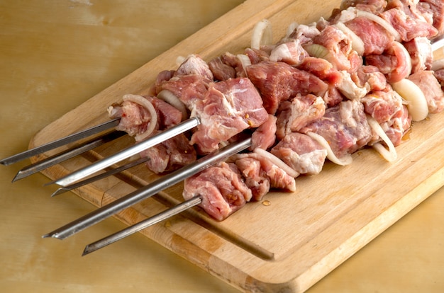 Raw meat with spices and onion strung on a skewer