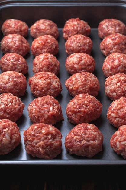 Raw meatballs on Baking trays are prepared and ready for baking in the oven selective focus