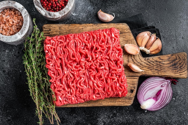 Raw Mince minced Ground beef meat on a cutting board Black background Top view