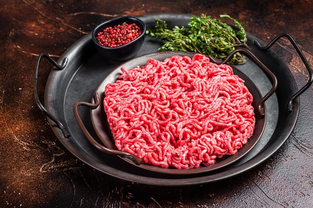 Raw Mince minced Ground beef meat in a kitchen tray Dark background Top view