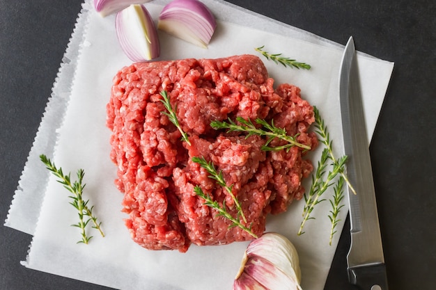 Raw minced meat with thyme and spices for cooking cutlets, hamburgers, meatballs.