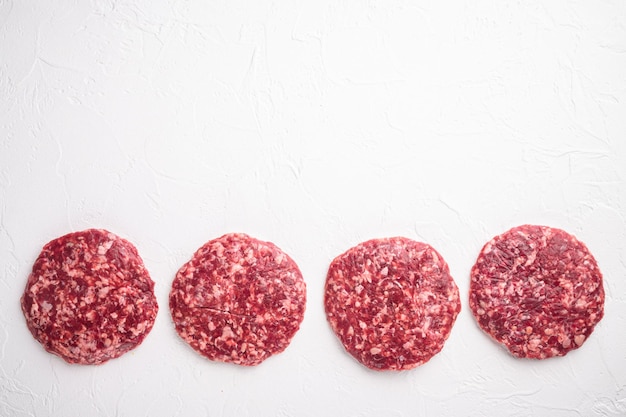 Photo raw minced steak burgers from beef meat set, on white stone  background, top view flat lay, with copy space for text