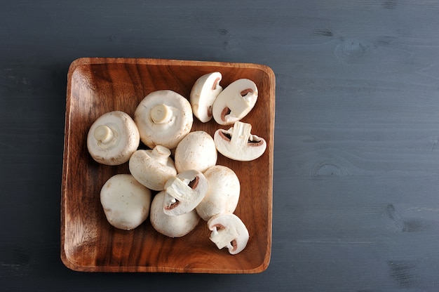 Raw Mushrooms whole and chopped on a wooden  