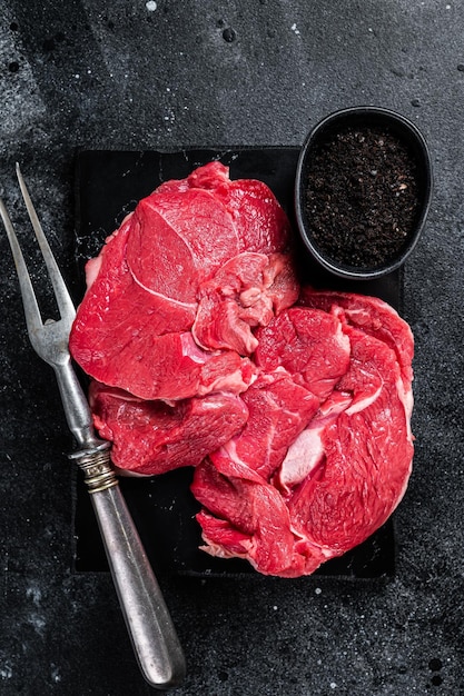 Raw Mutton fillet steaks from leg uncooked lamb meat Black background Top view