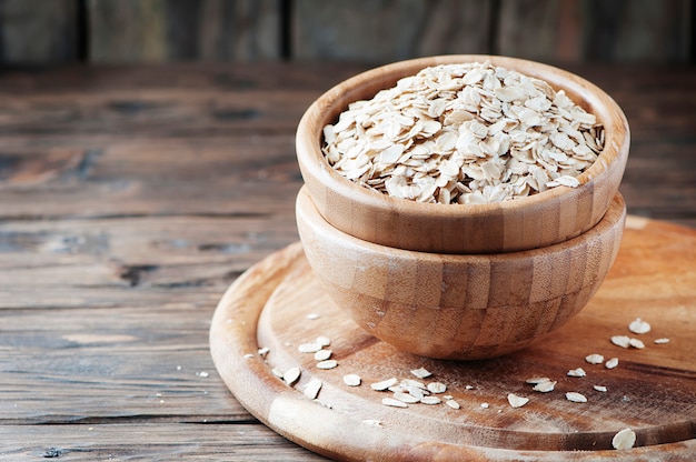 Raw oatmeal cereal on the wooden table