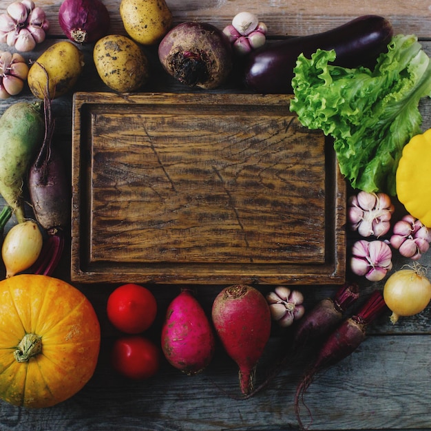 Raw organic fresh vegetables and wooden board in rustic style