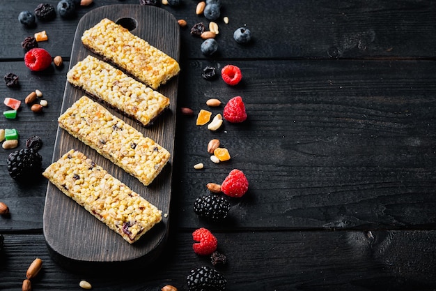 Raw organic granola bars with seeds and nuts with copy space on black wooden table