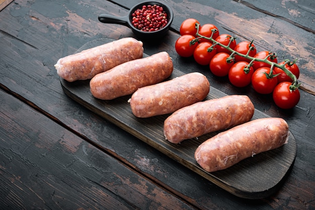 Raw organic pork sausages, on old dark wooden table.