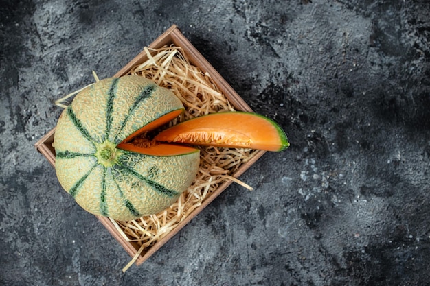 Raw Organic Tuscan Melon Cantaloupe Yellow pieces of melon on a wooden board on a dark background banner menu recipe place for text top view