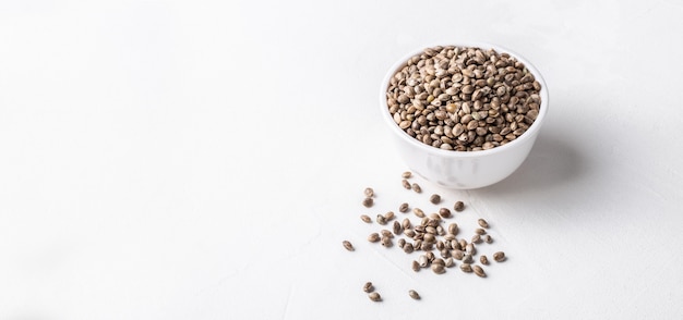 Raw organic unrefined hemp seeds in small white bowl