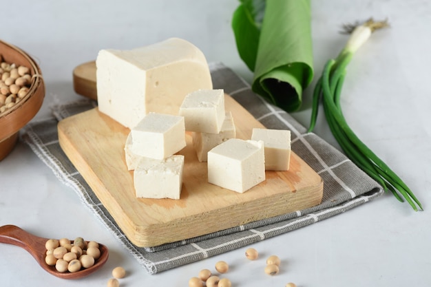 Raw organic vegetarian tofu cubes on wooden background