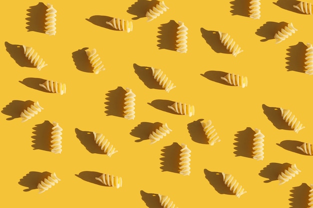 raw pasta on a bright yellow background Food pattern