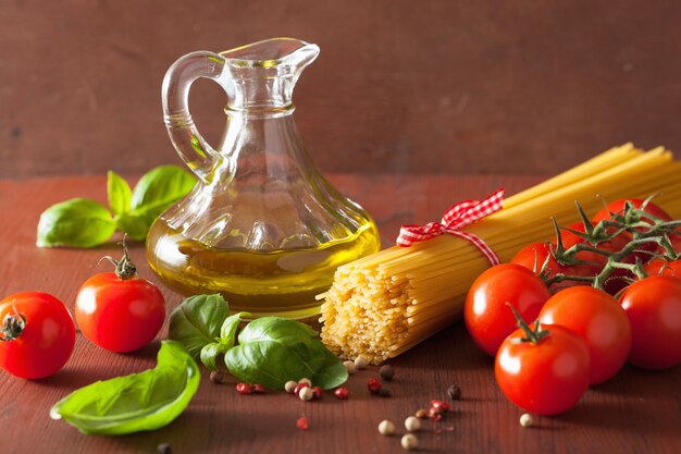 Raw pasta olive oil tomatoes. italian cuisine in rustic kitchen