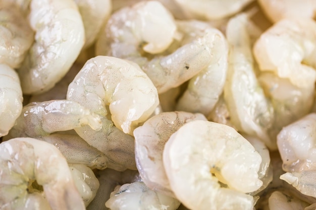 Raw peeled shrimp on a brown butcher paper.