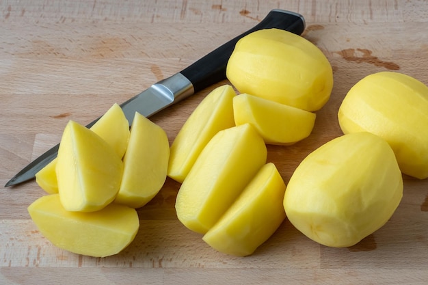 Raw peeled and sliced potatoes on cutting board