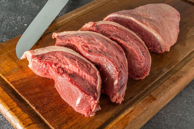 Raw picanha steaks on cutting board