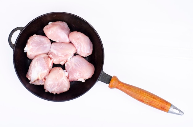 Raw pieces of chicken leg in skillet for cooking. Studio Photo.