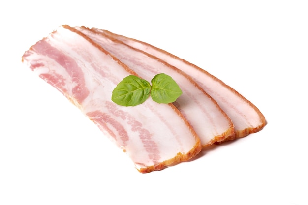 Raw pieces of fresh bacon with basil leaf green isolated on a white background