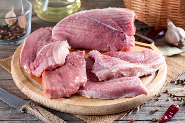 Raw pork chops ready to Cook on a wooden board in the rustic kitchen. Fresh pork.