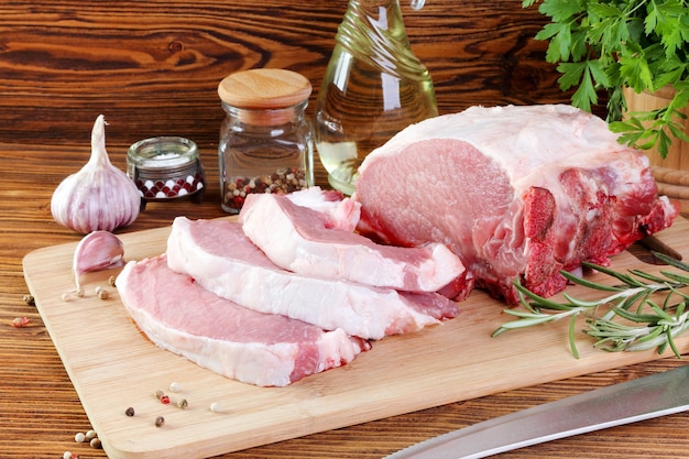 Raw pork fillet on a cutting board, cut into steaks