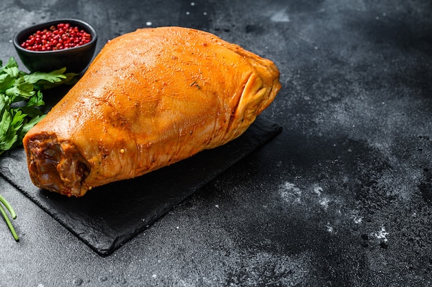 Raw pork leg with herbs and marinate on table. Black background. Top view.