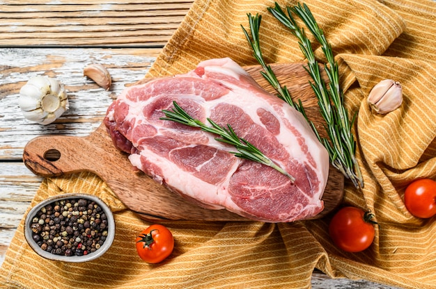 Raw pork neck chop meat with herb leaves and spices