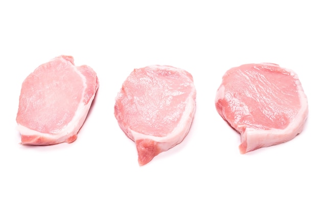 Raw pork pieces isolated on a white surface. Top view.