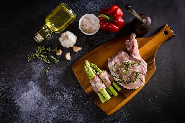 Raw pork ribs on chopping board with vegetables and spices, top view