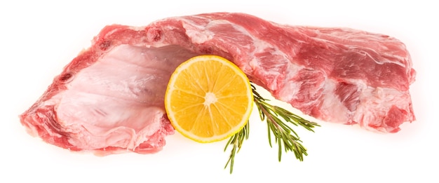 Raw pork ribs with rosemary and lemon on a white background isolate