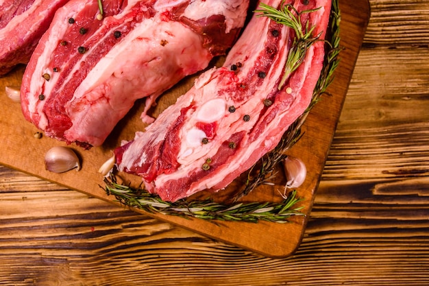 Raw pork ribs with spices garlic and rosemary on a cutting board Top view