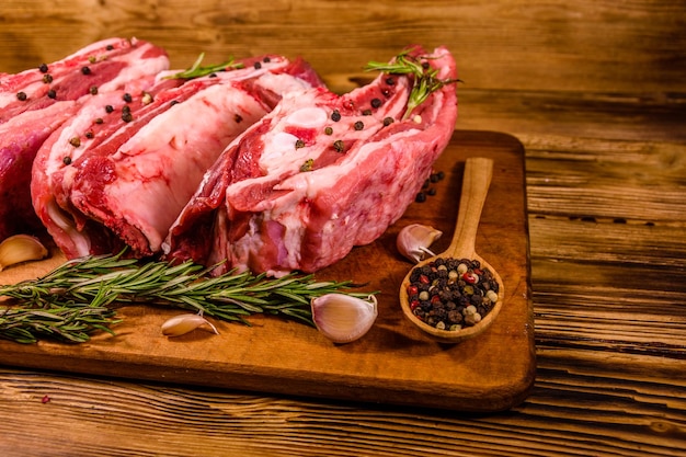 Raw pork ribs with spices garlic and rosemary on a cutting board