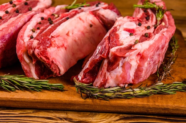 Raw pork ribs with spices and rosemary on a cutting board