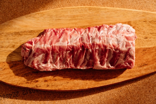 Raw pork ribs on a wooden cutting board.