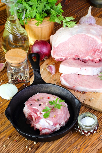 Raw pork steak in a frying pan on a kitchen table