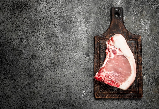 Raw pork steak. on rustic background