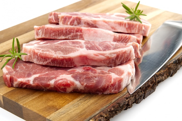 Raw pork steak on wooden cutting board