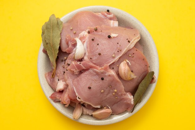 Raw pork with black pepper, garlic and bay leaf on dish