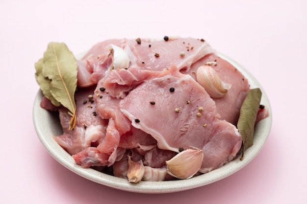 Raw pork with black pepper, garlic and bay leaf on dish