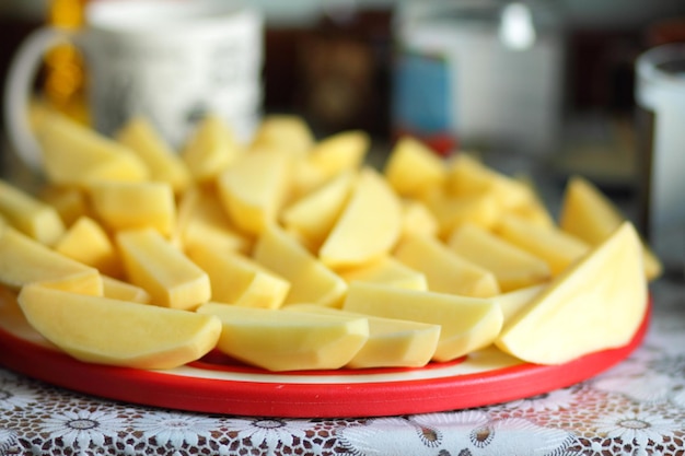 Raw potato waiting to be cooked Raw potato wedges on cutting board in home kitchen Potatoes prepared for grill