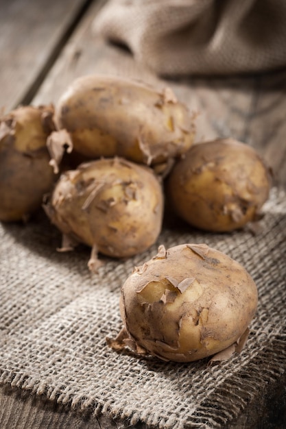 Raw potatoes on wooden table