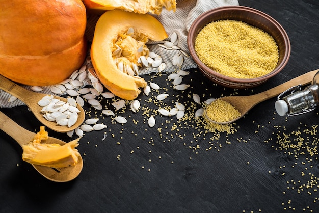 Raw pumpkin and lentil seed on black wooden background. Top view. Copy space