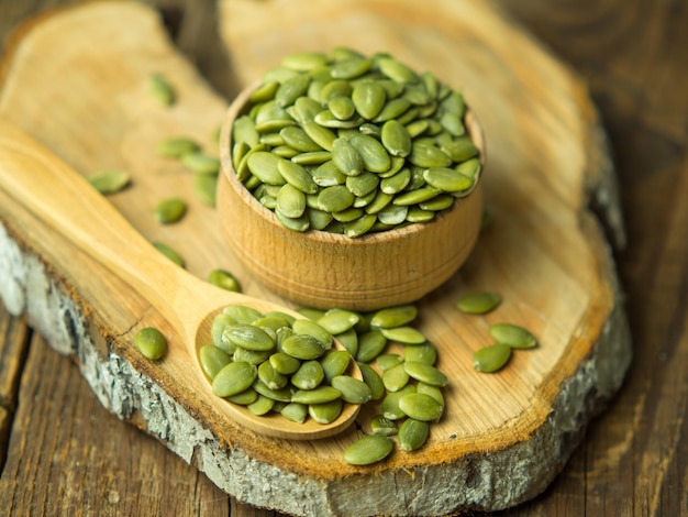 raw pumpkin seeds on old wooden background copy space