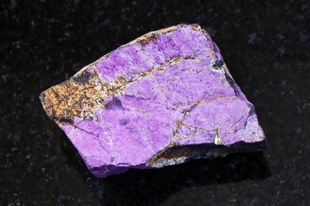 Raw Purpurite stone on dark background