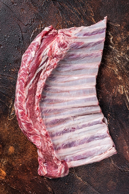 Raw rack of mutton lamb ribs on butcher board